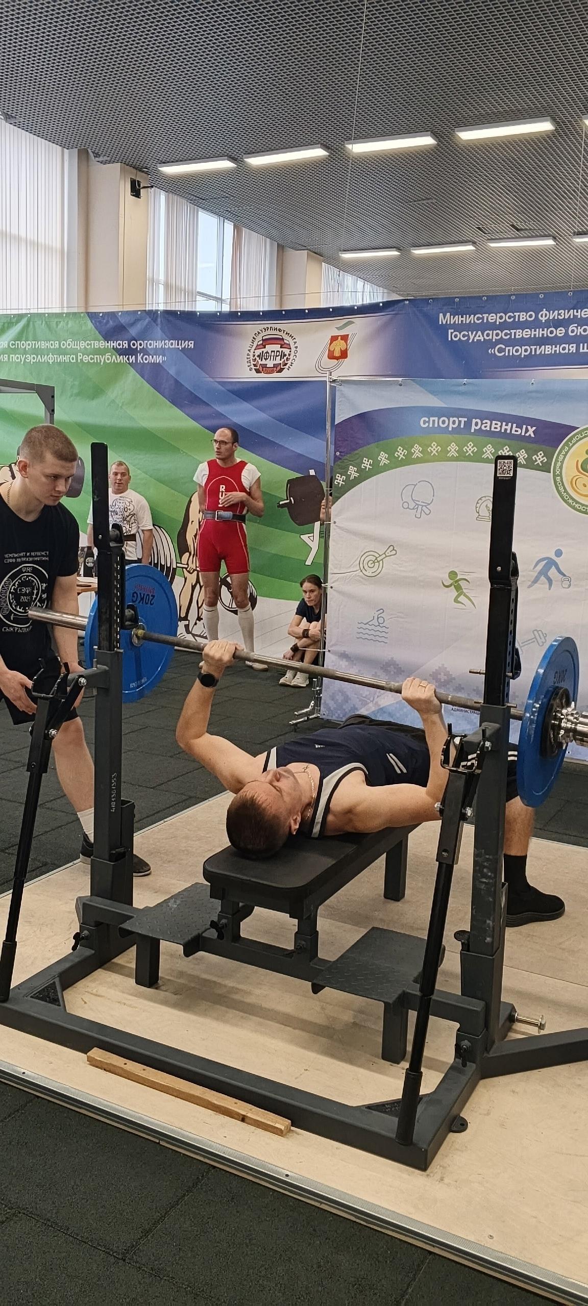 Спортсмен выполняет жим штанги лежа во время первенства