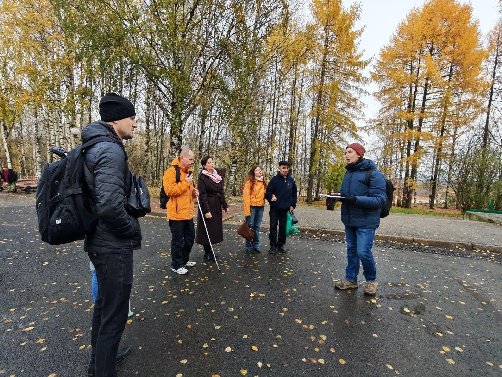 Группа людей слушает экскурсовода в осеннем парке Сыктывкара